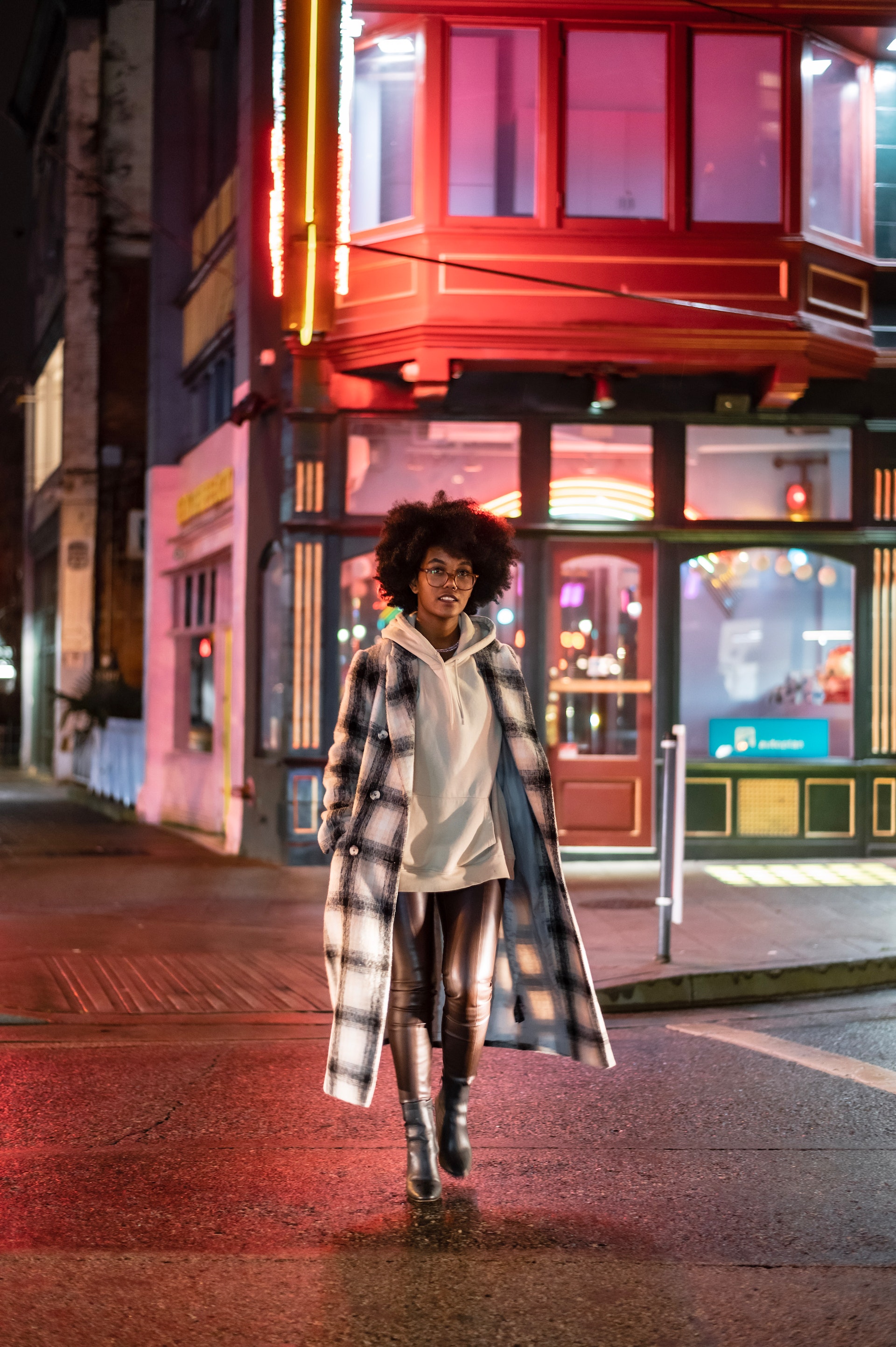 stylish woman crossing road at night